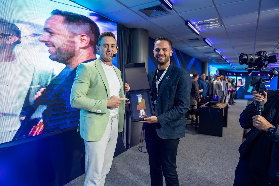 Rubens Sousa recebendo uma premiação no palco de um evento de empresários